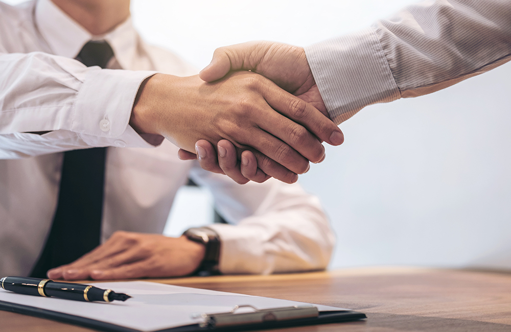Real estate broker agent and customer shaking hands after signin